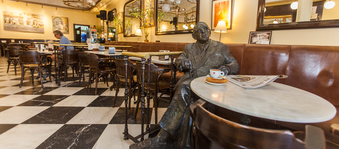 Imagen frontal de la estatua de Torrente Ballester en el Café Novelty